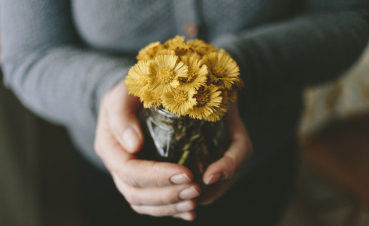 Kvinna håller gula blommor